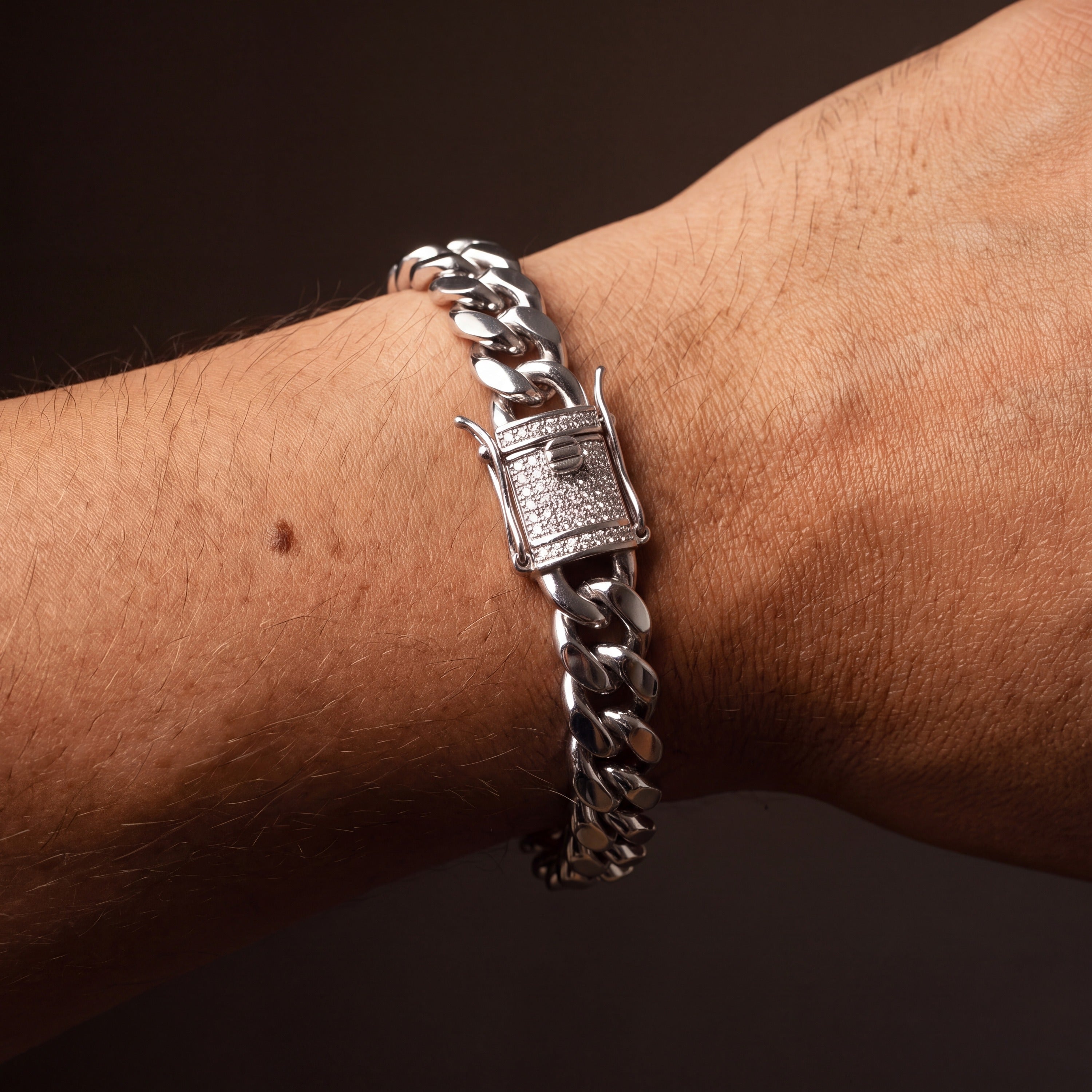Stainless steel Miami Cuban link bracelet worn on a wrist, plain polished links with a pave clasp